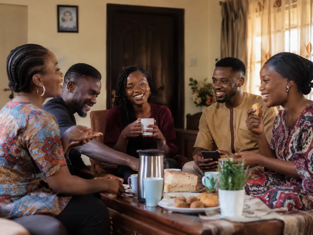 Friends sharing tea, bread and conversation in a Nigerian home